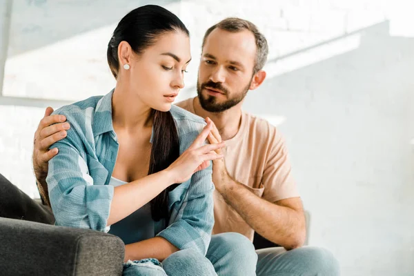 Culpable hombre corriendo y tratando de consolar a la esposa después de discutir - foto de stock