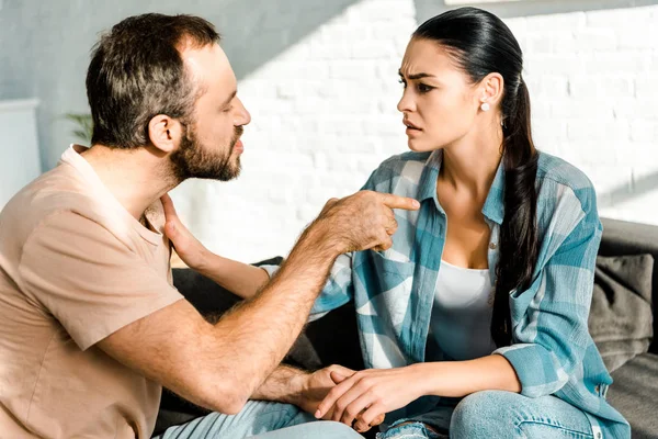 Pareja teniendo discusión y marido insultando esposa en casa — Stock Photo