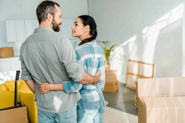 Glückliches Paar umarmt sich beim Packen für neues Haus, bewegliches Konzept — Stockfoto