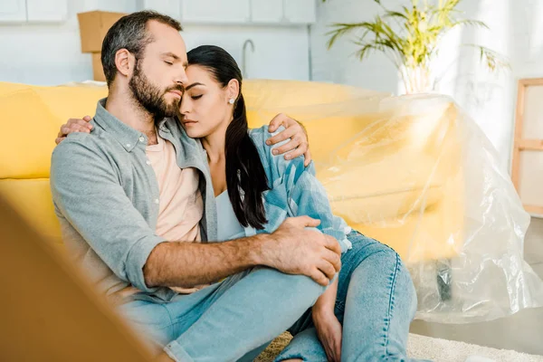 Mari et femme assis sur le canapé et se reposant après l'emballage pour la nouvelle maison, concept de déménagement — Photo de stock