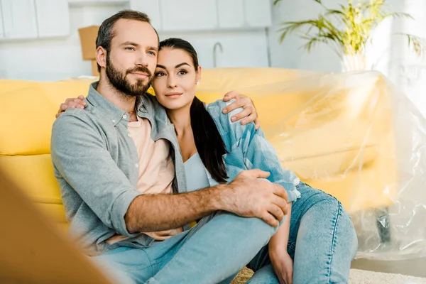 Marito e moglie seduti sul divano dopo aver imballato per la nuova casa, concetto in movimento — Foto stock