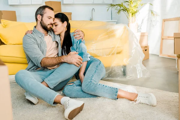 Bonito marido e mulher descansando depois de embalagem para casa nova, conceito em movimento — Fotografia de Stock