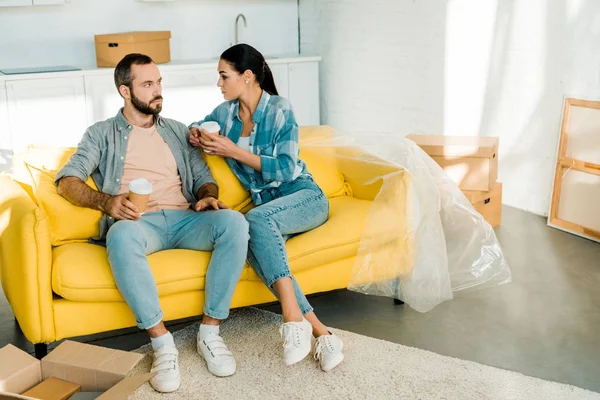 Schönes Ehepaar auf Couch sitzend und Kaffee trinkend beim Packen für neues Haus, bewegendes Konzept — Stockfoto