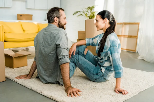Husband and wife sitting on floor while packing for new house, moving concept — Stock Photo