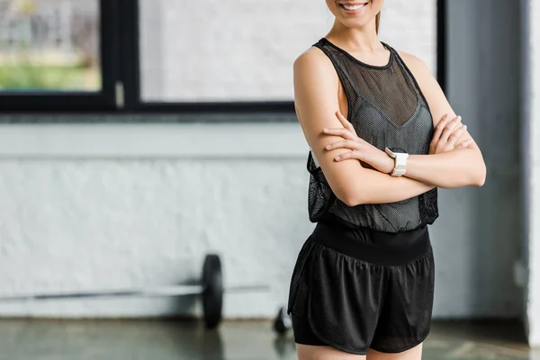 Section médiane de sportive souriante en noir au gymnase — Photo de stock