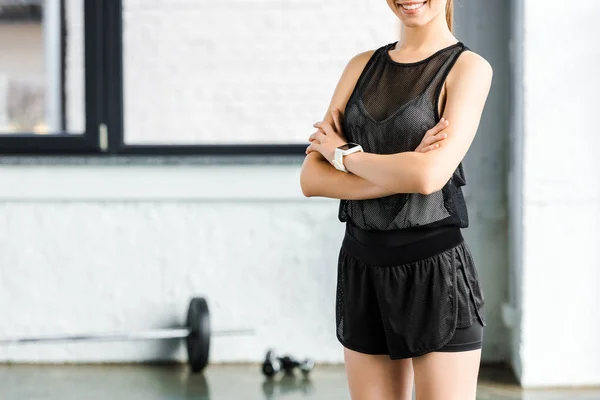 Cropped view of smiling sportswoman in black at gym — Stock Photo