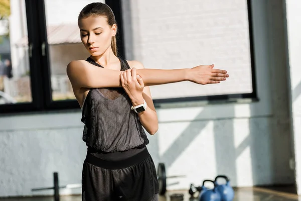 Красивая спортсменка делает упражнения перед тренировкой в тренажерном зале — стоковое фото