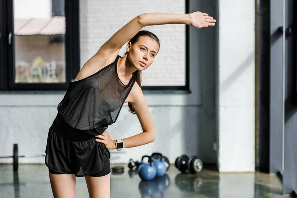 Attraktive, flexible Sportlerin beim Stretching vor dem Training im Fitnessstudio — Stockfoto