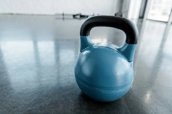 Large blue kettlebell on gym floor with copy space — Stock Photo