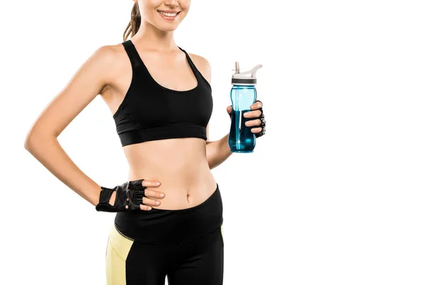 Vista recortada de la deportista sonriente sosteniendo botella deportiva aislada en blanco - foto de stock
