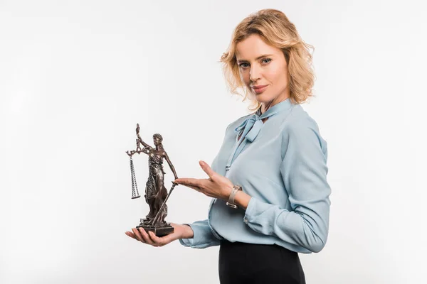 Жінка-адвокат тримає статую леді правосуддя і посміхається на камеру ізольовано на білому — стокове фото