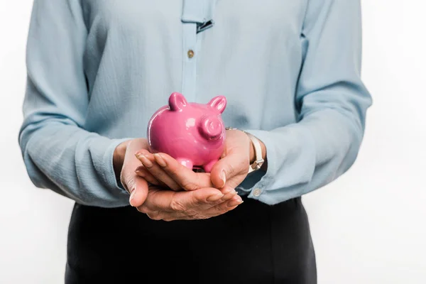 Primer plano vista parcial de la mujer de negocios sosteniendo alcancía rosa aislado en blanco - foto de stock