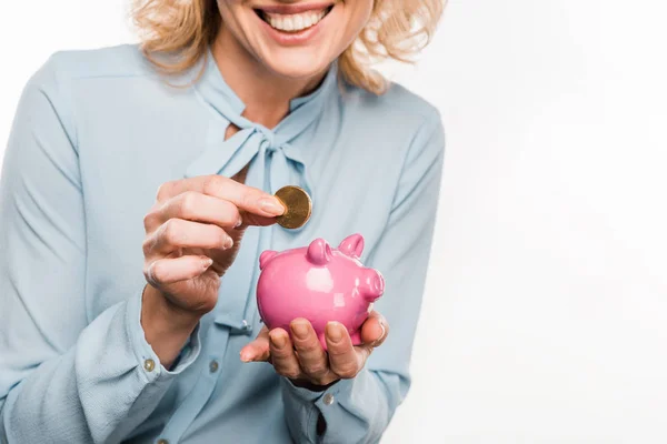 Recortado disparo de sonriente mujer de negocios sosteniendo alcancía y moneda aislada en blanco - foto de stock