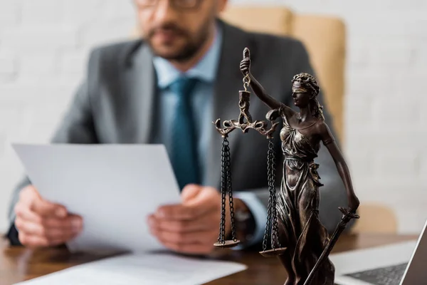 Close-up view of lady justice statue and lawyer working working with papers behind — Stock Photo