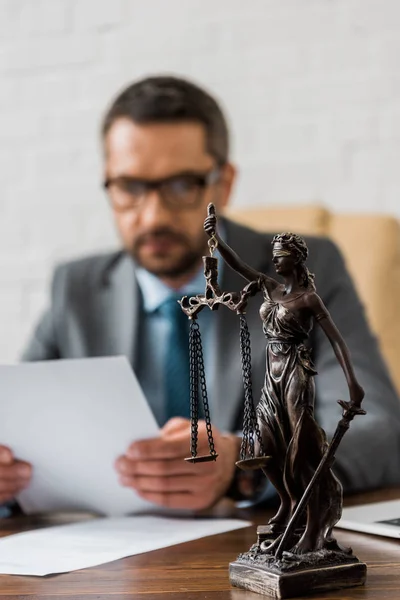 Close-up vista de senhora justiça estátua e advogado do sexo masculino trabalhando atrás — Fotografia de Stock