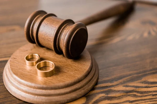 Vista close-up de martelo de madeira e anéis de casamento na mesa, conceito de divórcio — Fotografia de Stock