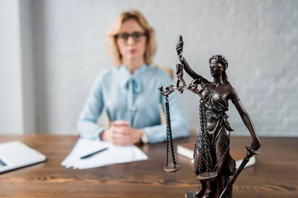 Vista de cerca de la estatua de la señora justicia y abogada que trabaja detrás - foto de stock