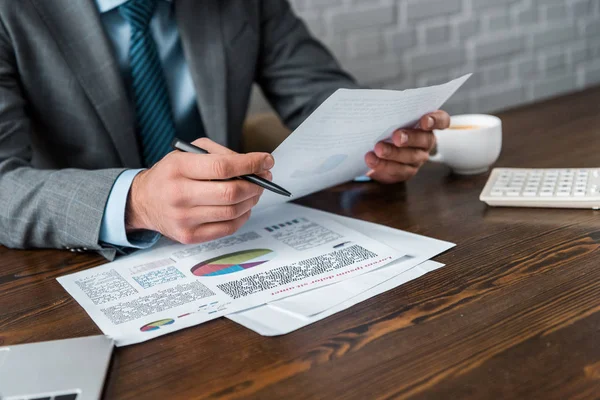 Schnappschuss von Geschäftsmann, der Papierkram am Arbeitsplatz erledigt — Stockfoto