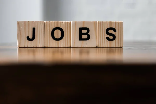 Close-up shot of blocks with JOBS sign on wooden table — Stock Photo