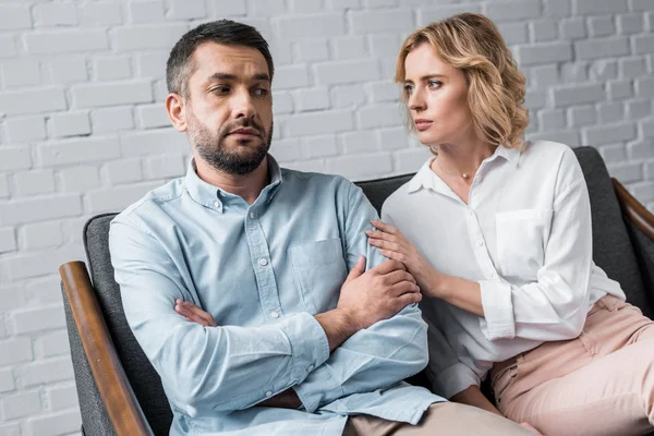 Femme parlant à mari déprimé assis sur le canapé après la querelle — Photo de stock