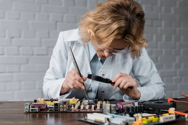 Concentrated female computer engineer repairing motherboard — Stock Photo