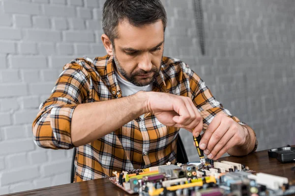 Computer engineer repairing motherboard with screwdriver — Stock Photo