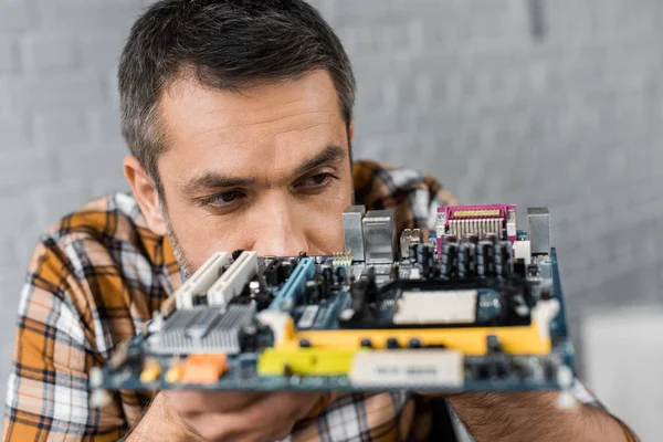 Portrait en gros plan d'un bel ingénieur en informatique avec carte mère — Photo de stock