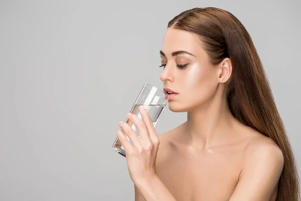 Bella donna nuda bere acqua pura isolato su grigio — Foto stock