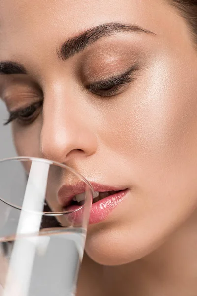 Nahaufnahme einer schönen Frau, die Wasser aus Glas trinkt — Stockfoto