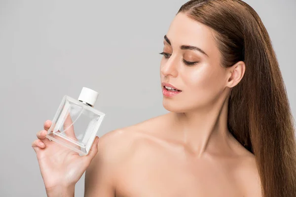 Bela menina nua segurando frasco de perfume isolado em cinza — Fotografia de Stock