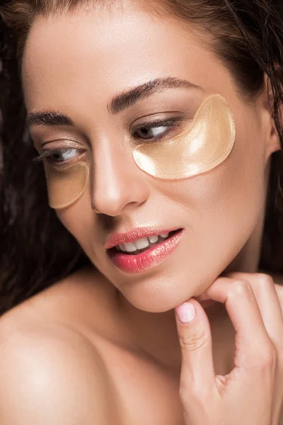 Hermosa mujer joven con parches para los ojos de colágeno, aislado en gris - foto de stock