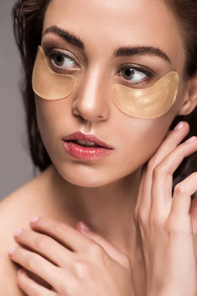 Beautiful girl with golden collagen eye patches, isolated on grey — Stock Photo