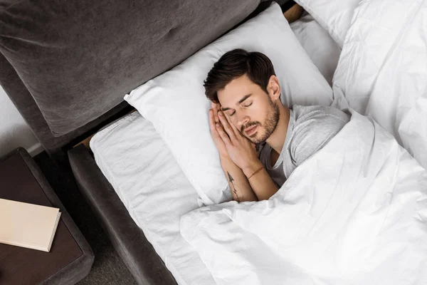 Vista dall'alto del bel giovane che dorme a letto — Foto stock