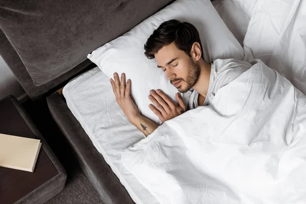 Top view of handsome young man sleeping in bed in the morning — Stock Photo
