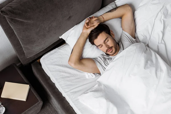 Vue de dessus du beau jeune homme barbu dormant au lit — Photo de stock