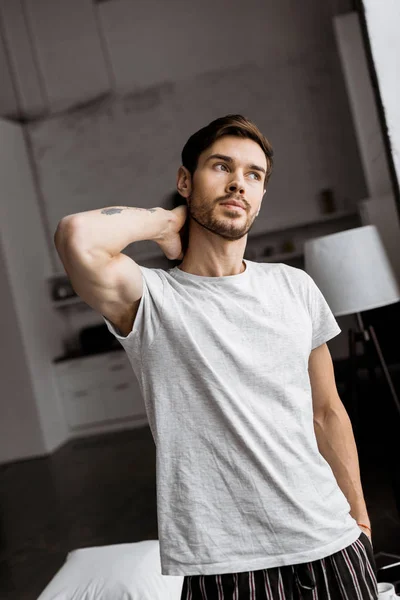 Joven guapo en pijama mirando a casa - foto de stock