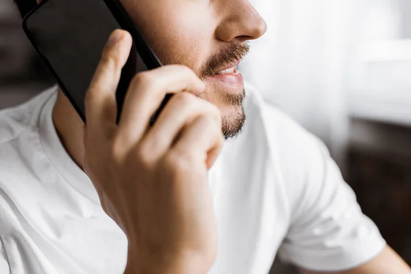 Recortado disparo de hombre joven hablando por teléfono inteligente - foto de stock