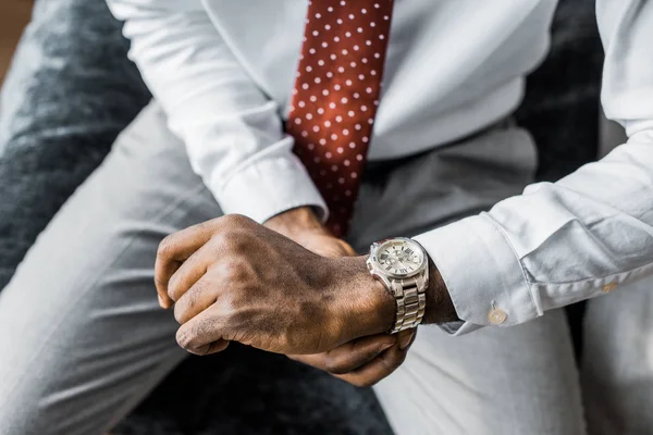 Обрезанный вид элегантного бизнесмена, смотрящего на наручные часы — стоковое фото