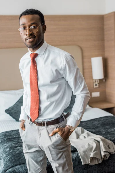 Smiling businessman in red tie standing in hotel room — Stock Photo