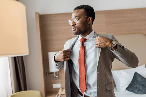 Uomo d'affari afroamericano con giacca grigia in camera d'albergo — Foto stock