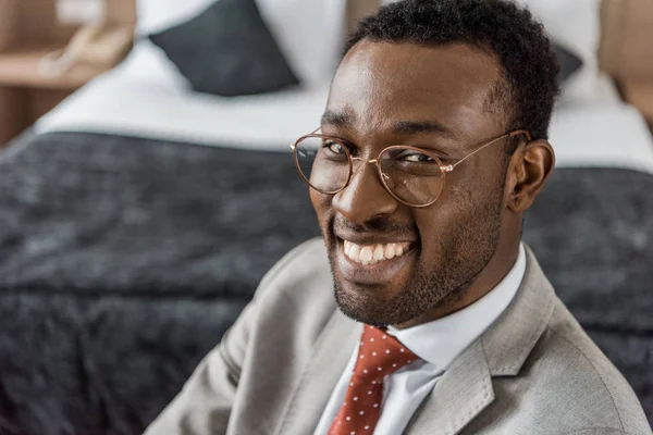 Smiling african american businessman in eyeglasses and formal wear — Stock Photo