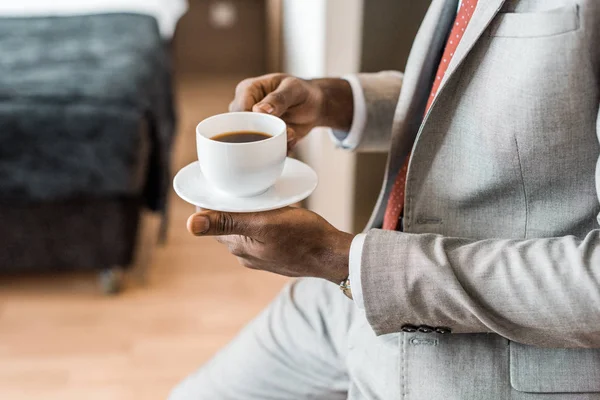 Обрізаний вид на елегантний афроамериканський чоловік тримає чашку кави — стокове фото