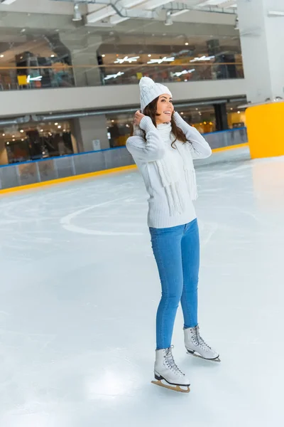 Весела молода жінка в білому светрі катається на ковзанах сама — стокове фото