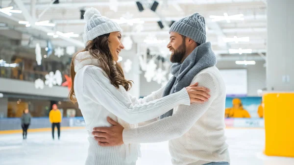 Vista laterale di coppia romantica sorridente sulla pista di pattinaggio — Foto stock