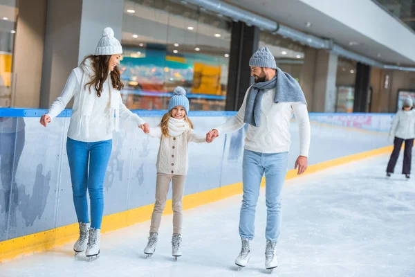 Famiyl holding hands while skating on rink together — Stock Photo
