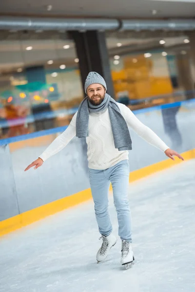 Bärtiger Mann mit Strickmütze und Pullover läuft auf Eisbahn — Stockfoto