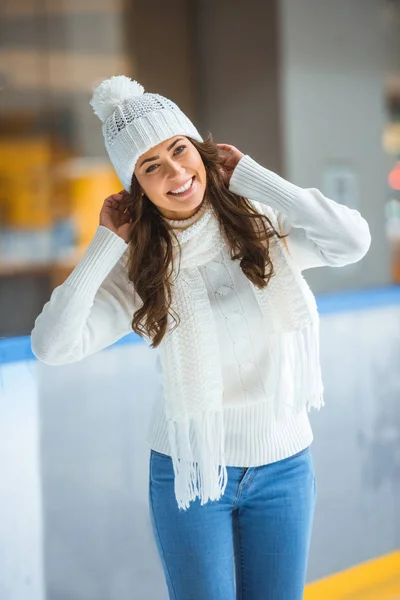 Portrait of happy young woman looking at camera while skating on ice rink — Stock Photo