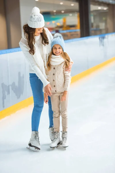 Enfant souriant et mère sur patinoire — Photo de stock