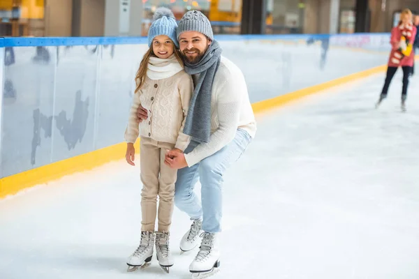 Heureuse petite fille et père sur patinoire — Photo de stock