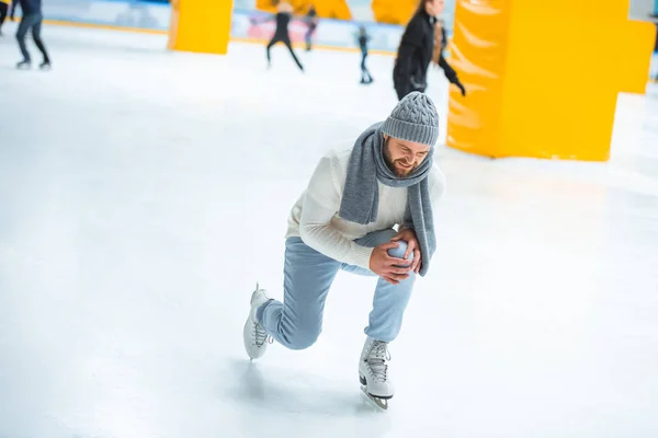 Mann verletzte sich beim Schlittschuhlaufen auf Eisbahn am Knie — Stockfoto